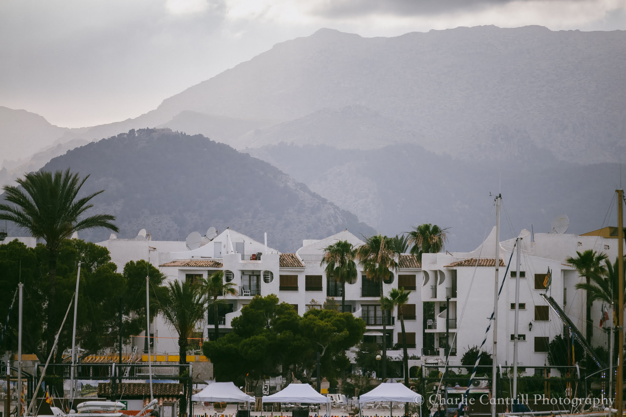 White buildings with mountain backdrop in cloudy weather